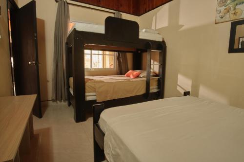 Habitación pequeña con 2 camas y ventana en Apartamentos Turísticos Casa Manuela, en San Andrés