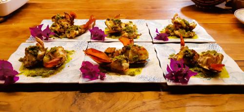 a bunch of food on a plate on a table at Beach House Lodge in Poum