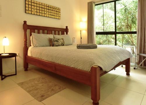 a bedroom with a large bed with a large window at Cairns Rainforest Retreats in Bellenden Ker