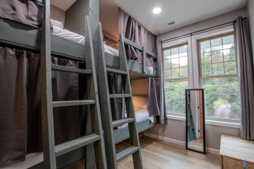 a room with bunk beds and a window at The Lazy Tiger Hostel in Woodfin