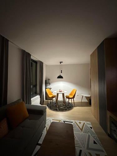 een woonkamer met een bank en een tafel bij Bjelasnica studio apartment in Bjelašnica