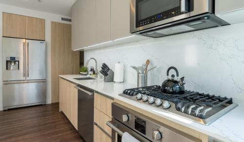 a kitchen with a stove top oven next to a refrigerator at Stylish Condo By The Beach in Los Angeles