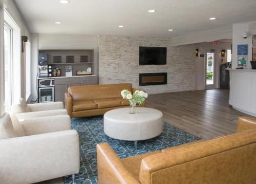 a living room with couches and a table in a room at Days Inn by Wyndham Kelowna in Kelowna