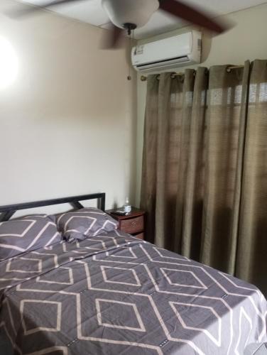 a bedroom with a bed and a ceiling fan at Hostal EL VALLE in Los Algarrobos