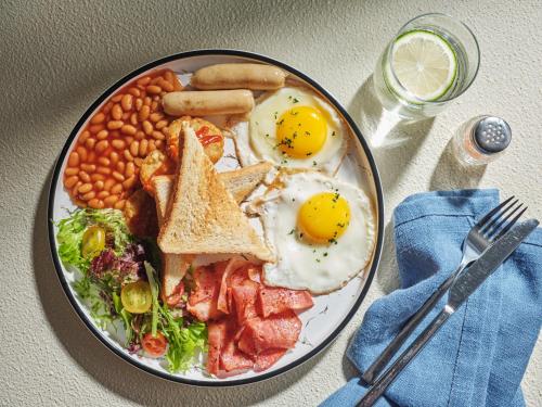 a plate of breakfast food with eggs bacon beans and toast at AC Hotel by Marriott Suzhou, Guan Qian in Suzhou