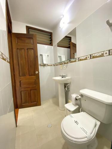 a bathroom with a toilet and a sink at Hotel San Julian in Buga