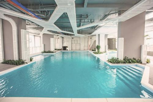 Una gran piscina con agua azul en un edificio. en Roomio De Capella - Share Apartment, en Ho Chi Minh