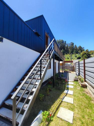 a house with a staircase next to a building at Departamento en Cocholgüe Tomé Concepción in Tomé