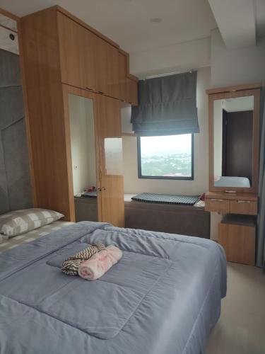ein Schlafzimmer mit einem großen Bett mit einer blauen Decke in der Unterkunft Apartment TransPark Cibubur, TSM in Kalimanggis