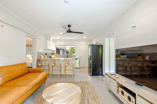 a living room with a couch and a table at The Tropical Trinity - A Breezy Beachside Getaway in Trinity Beach