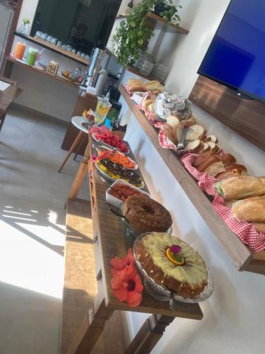 een tafel gevuld met verschillende soorten brood en gebak bij Pousada Casa Da Praia in Florianópolis