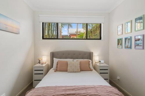 een slaapkamer met een bed met 2 nachtkastjes bij Coastal Palms Escape - Your Ideal Family Getaway in Barrack Point
