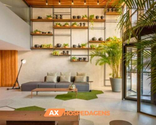 una sala de estar con sofá y estanterías con plantas en AX Infinity At The Sea, en João Pessoa