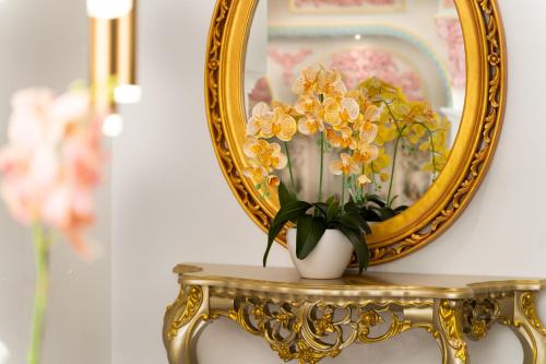 a vase of flowers on a table in front of a mirror at Arte by Thomas Chan in Kuala Lumpur