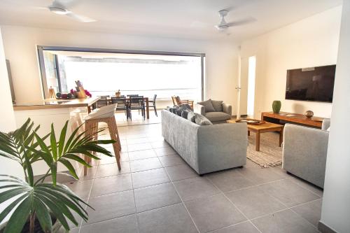 a living room with couches and a dining room at LA PLAGE MARTINIQUE in Schœlcher