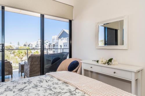 un dormitorio con una cama y un espejo en Palladio Haven Retreat, en Mandurah