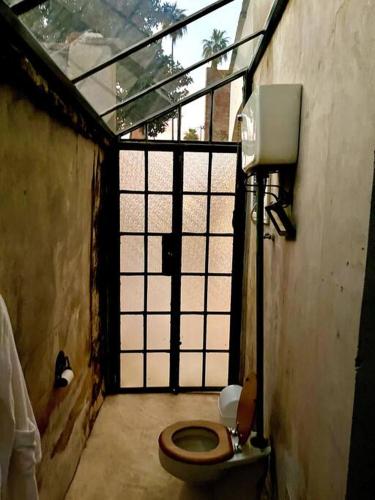 a bathroom with a toilet in a room with a window at Casa de Flaco in Álamos