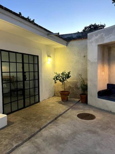 a garage with two potted plants in front of a house at Casa de Flaco in Álamos