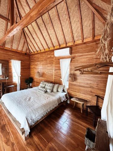 um quarto com uma cama num quarto de madeira em La pipa Uluwatu em Uluwatu