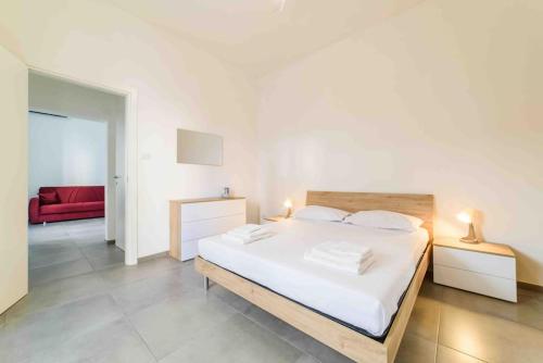 a bedroom with a large white bed and a red couch at [Incantevole Bilocale] Wi-Fi + Netflix in Salerno