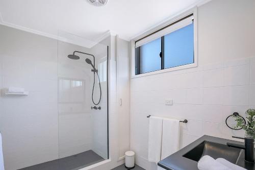 a bathroom with a shower and a sink and a window at The Hillside at Hamilton - A Fresh Riverfront Abode in Brisbane