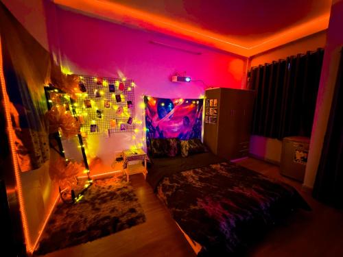 a bedroom with pink and purple lighting and a bed at LOPO homestay Ba Tháng Hai in Ho Chi Minh City