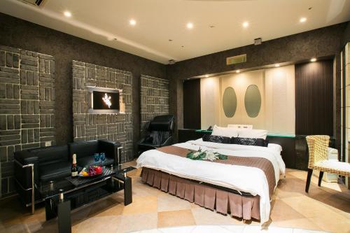 een slaapkamer met een bed, een bureau en stoelen bij Hotel AXIS -アクシス- in Osaka