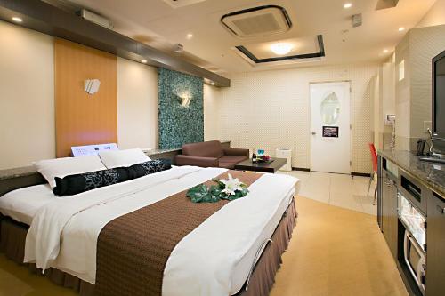 een hotelkamer met een groot bed en een woonkamer bij Hotel AXIS -アクシス- in Osaka