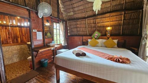 a bedroom with a bed in a room with wooden walls at Eden Lanta Bungalow in Phra Ae beach