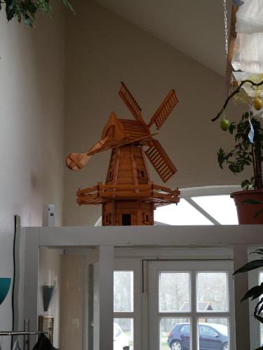a wooden model of a windmill on top of a door at Gasthuus Ulenhoff in Westoverledingen