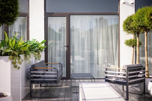 a balcony with two chairs and a window at Shanghai Autoongo Bund Hotel in Shanghai