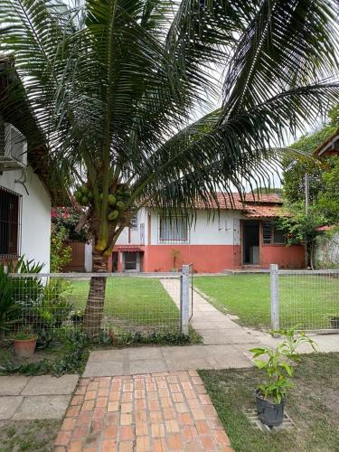 una casa con una palmera y una valla en Pousada completa em Mosqueiro, en Belém