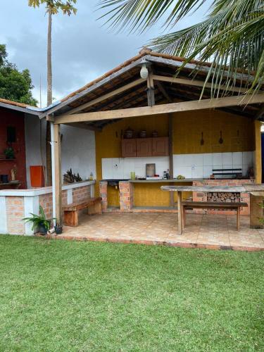 un patio de una casa con mesa y bancos en Pousada completa em Mosqueiro, en Belém