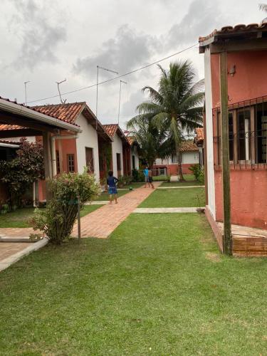 un grupo de personas caminando en un patio al lado de las casas en Pousada completa em Mosqueiro, en Belém