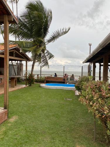 un patio trasero con una piscina y una palmera en Pousada completa em Mosqueiro, en Belém