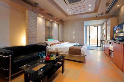 a living room with a bed and a couch at Hotel AXIS -アクシス- in Osaka