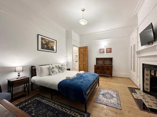 ein Schlafzimmer mit einem Bett und einem Kamin in der Unterkunft Hannah’s Place Near Finsbury Park in London
