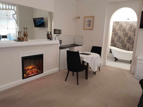 a living room with a fireplace and a table and a bath tub at Windarra on High in Launceston