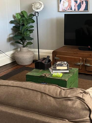 a living room with a green coffee table and a tv at The Muddy Duck in Harden