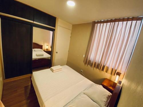 a small bedroom with a bed and a window at Departamento amoblado in Piura