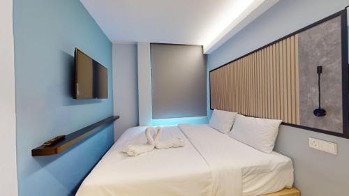 a bedroom with a white bed with a blue wall at Blue Lagoon At Bandar Sunway in Petaling Jaya
