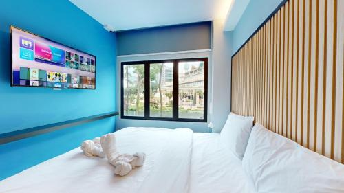 a bedroom with a white bed with a stuffed animal on it at Blue Lagoon At Bandar Sunway in Petaling Jaya