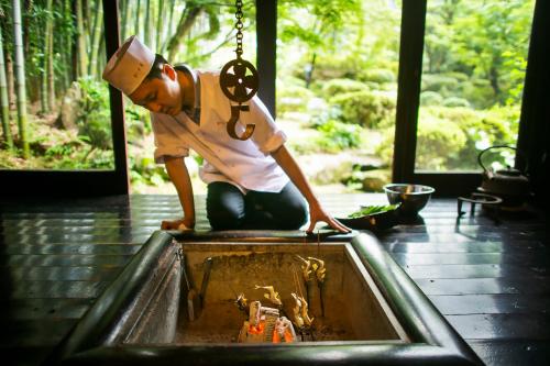 a man wearing a hard hat looking into a pool at 川魚・山菜料理　和田屋 in Hakusan