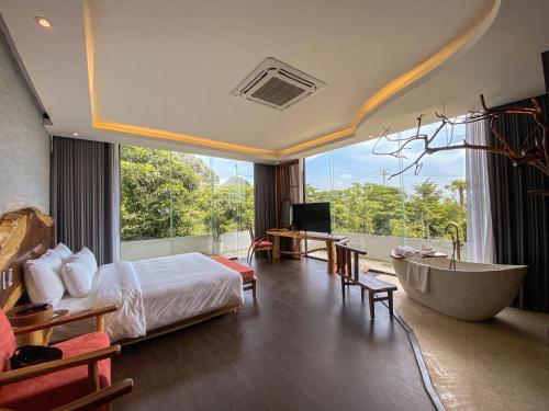 a bedroom with a tub and a bed and a bathroom at Minawa Kenhga Resort & Spa Ninh Binh in Ninh Binh