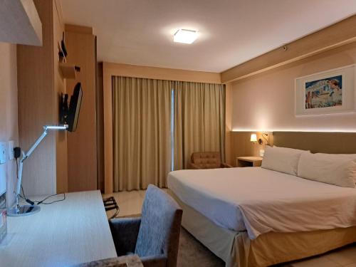 um quarto de hotel com uma cama e uma secretária em BSB STAY Flats particulares - CULLINAN em Brasília
