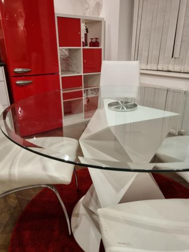 a glass table with a chair and a red cabinet at C'S LUXURIOUS Flat in Barking