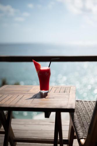 a red vase sitting on top of a wooden table at Rock'n Reef in Uluwatu