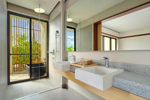 uma casa de banho com 2 lavatórios e um espelho em Sheraton Belitung Resort em Tanjungbinga