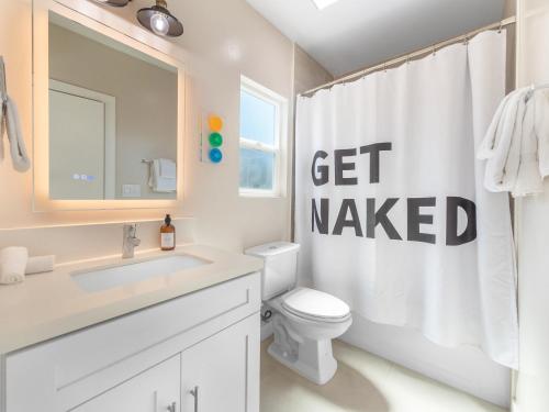 a bathroom with a toilet and a get wanted shower curtain at Beach Bungalow Perfection - Private Patios, BBQ walk2beach & Pet Friendly! in San Diego