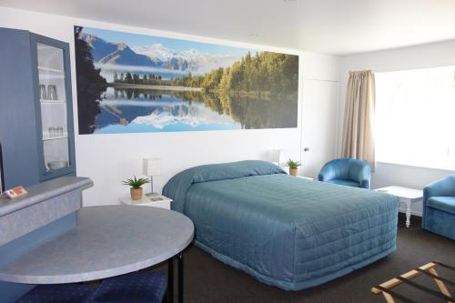a bedroom with a bed and a large painting on the wall at Northwood Motor Lodge in Christchurch